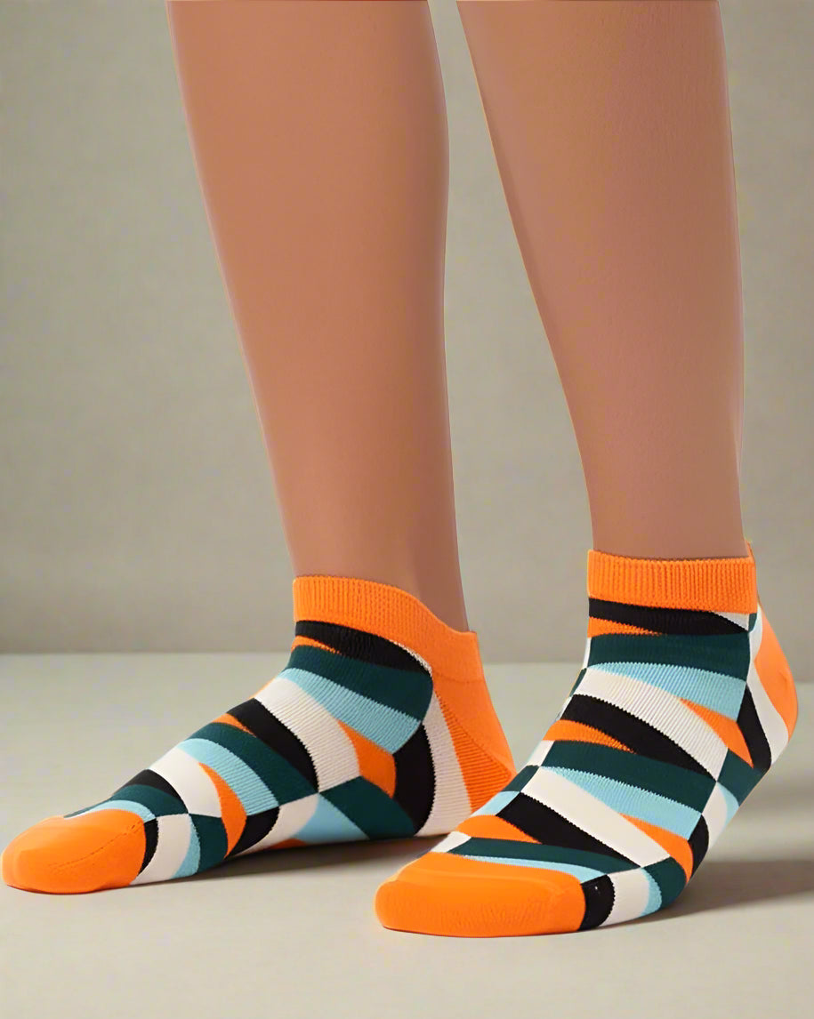 Colorful striped socks with orange accents worn by a person on a white background
