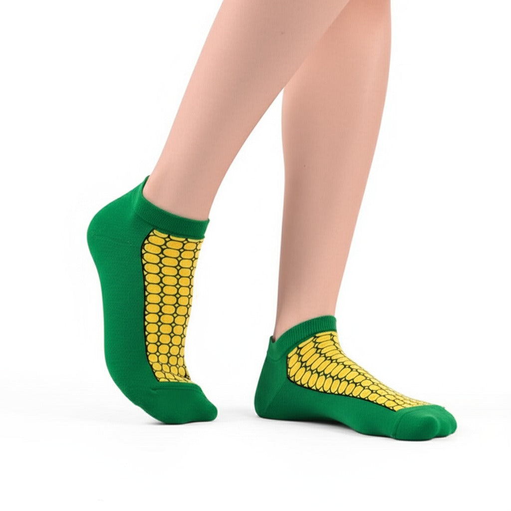 Green socks with yellow corn pattern worn by a person on a white background