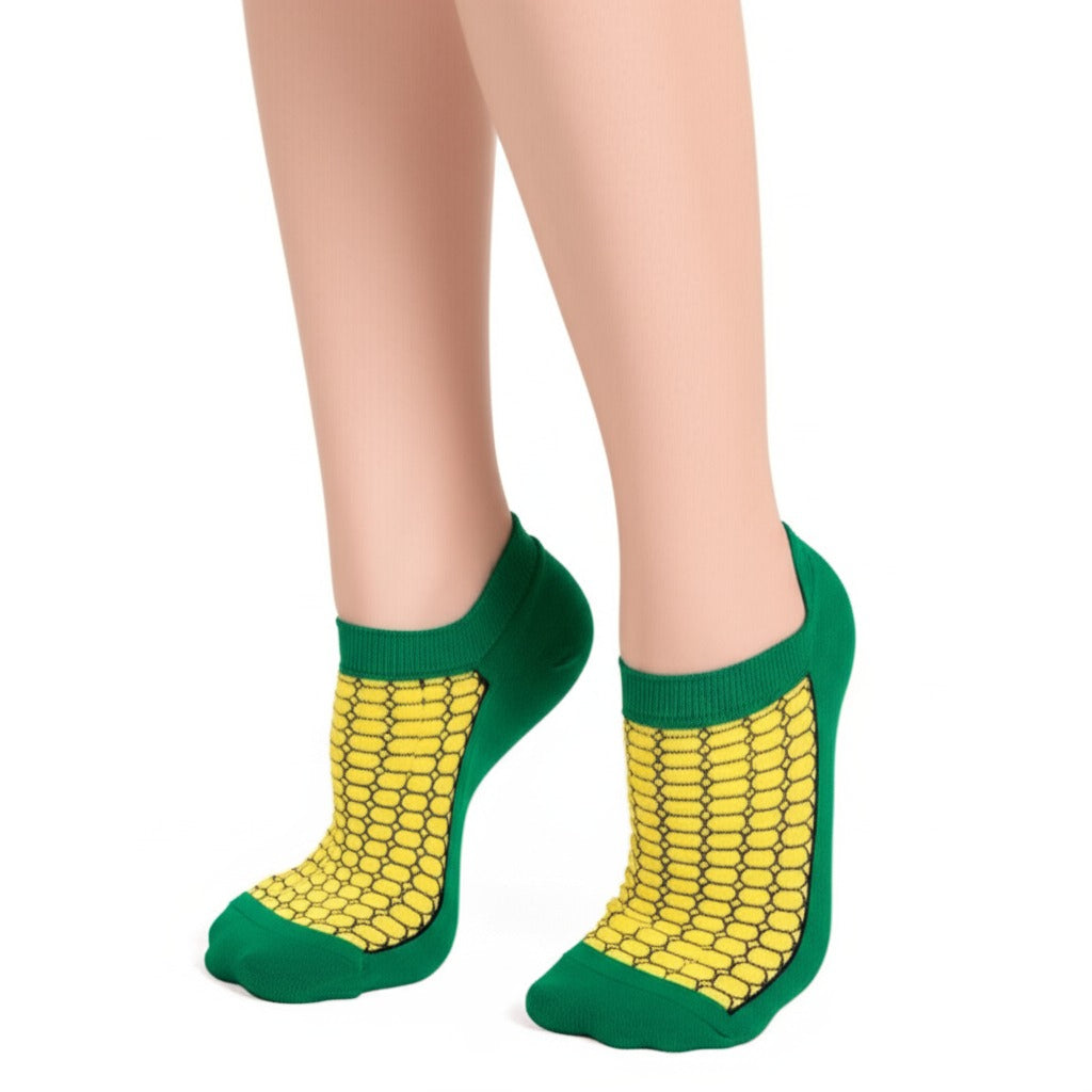 Green socks with yellow corn pattern worn by a person on a white background