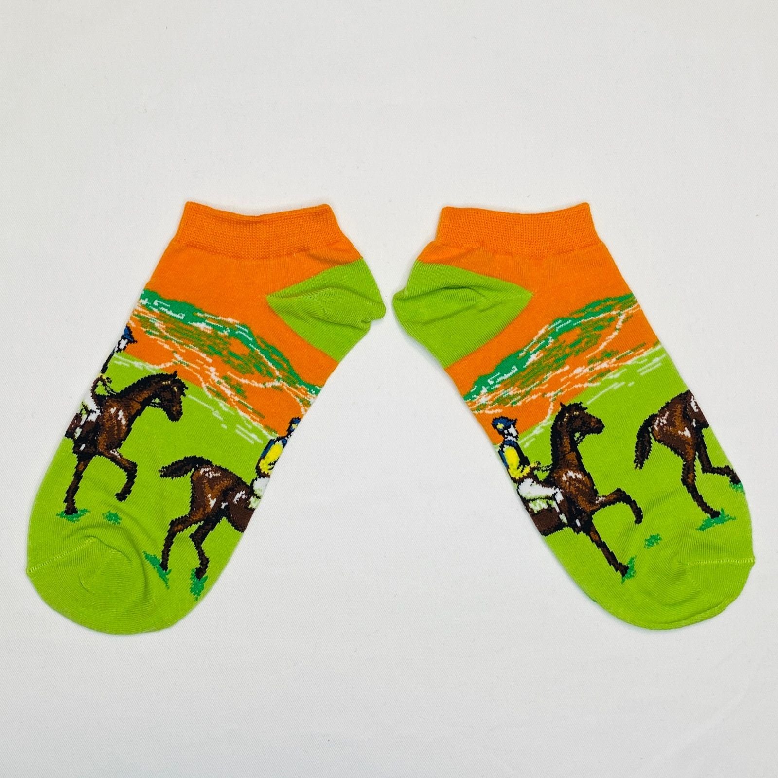 Pair of socks with horse and rider design on a white background