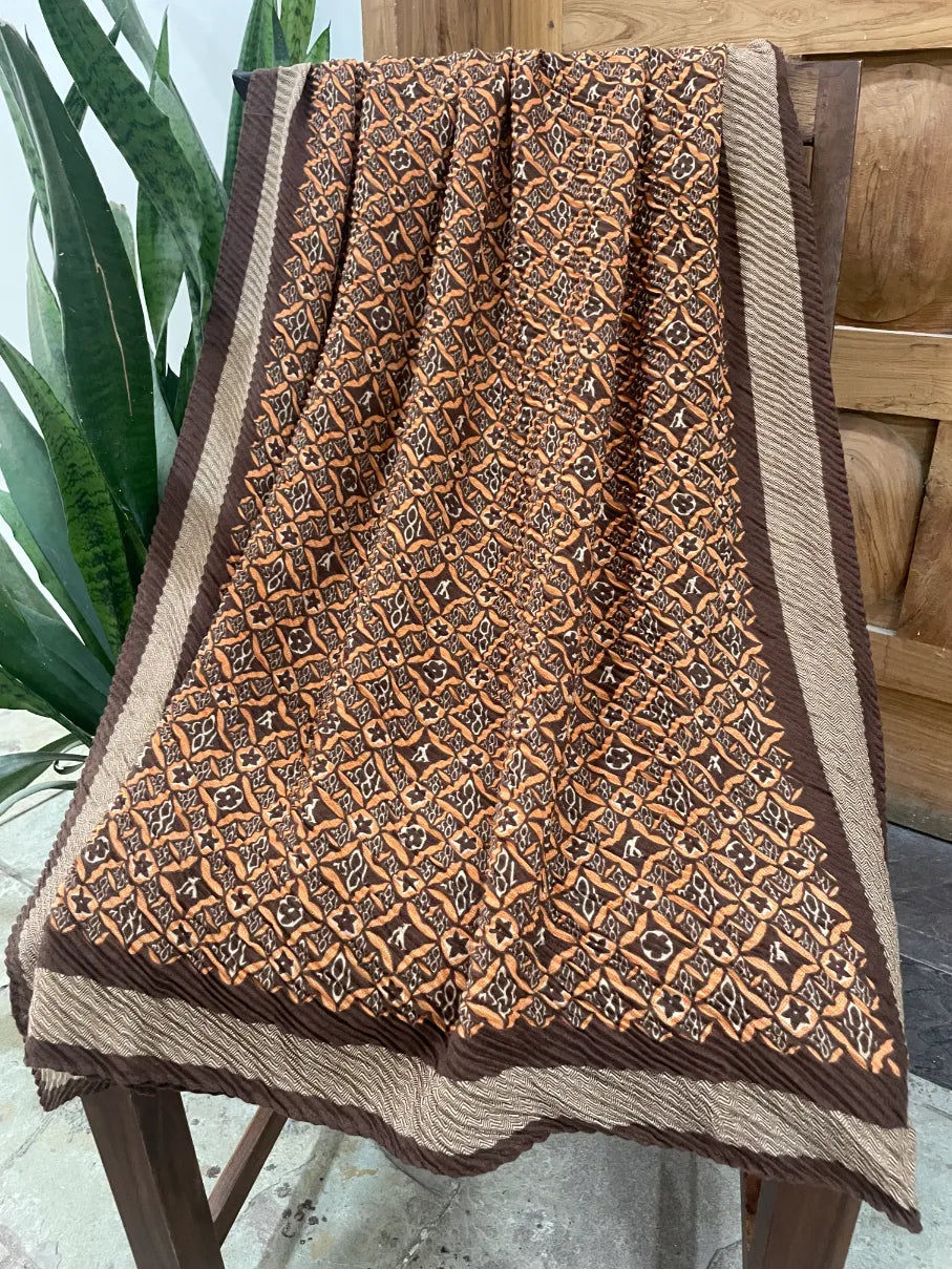 Full view of pleated brown monogram scarf showing chevron border detail