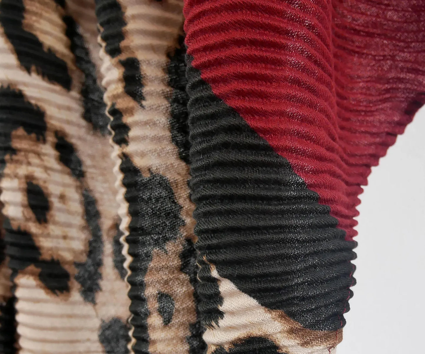 Close-up of textured scarf with leopard print and red and black pattern