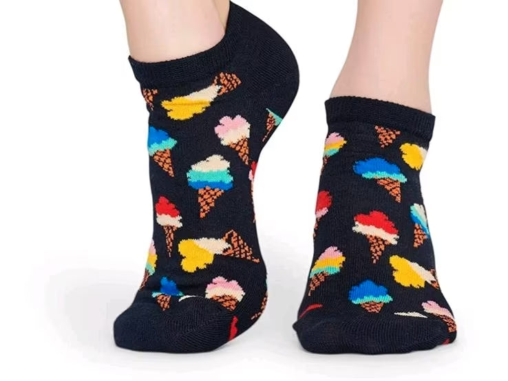 Black socks with colorful ice cream cone pattern worn by a person on a white background