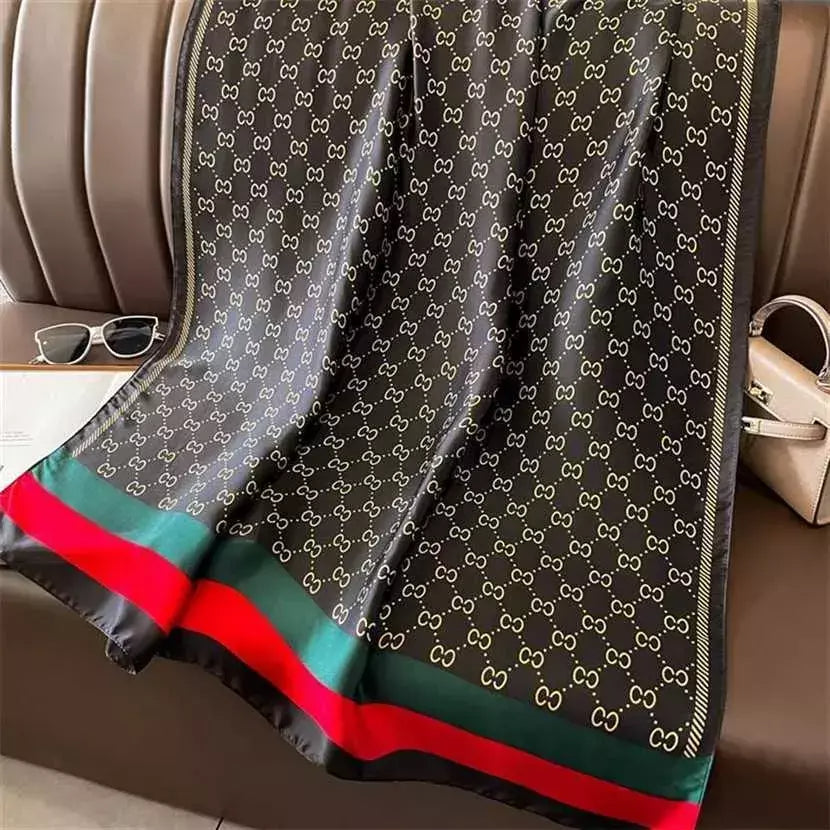 Discover timeless style with this luxurious silk-feel satin scarf. Featuring a classic black and gold monogram and an iconic red and green striped border, this 90 x 180 cm scarf is the epitome of elegance.