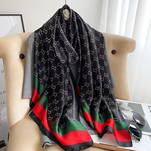 Discover timeless style with this luxurious silk-feel satin scarf. Featuring a classic black and gold monogram and an iconic red and green striped border, this 90 x 180 cm scarf is the epitome of elegance.