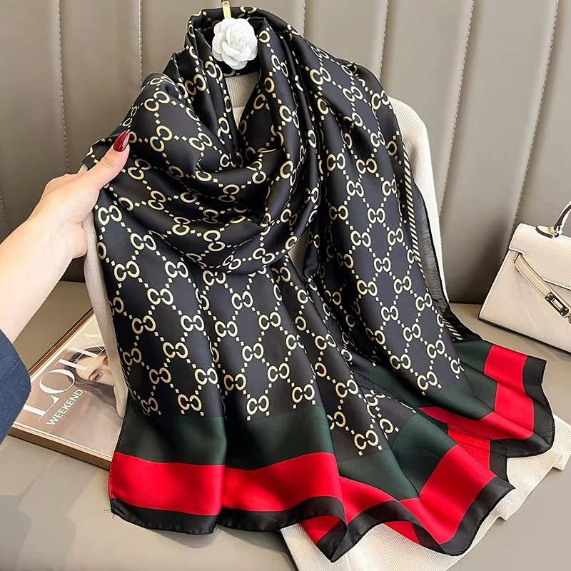 Discover timeless style with this luxurious silk-feel satin scarf. Featuring a classic black and gold monogram and an iconic red and green striped border, this 90 x 180 cm scarf is the epitome of elegance.