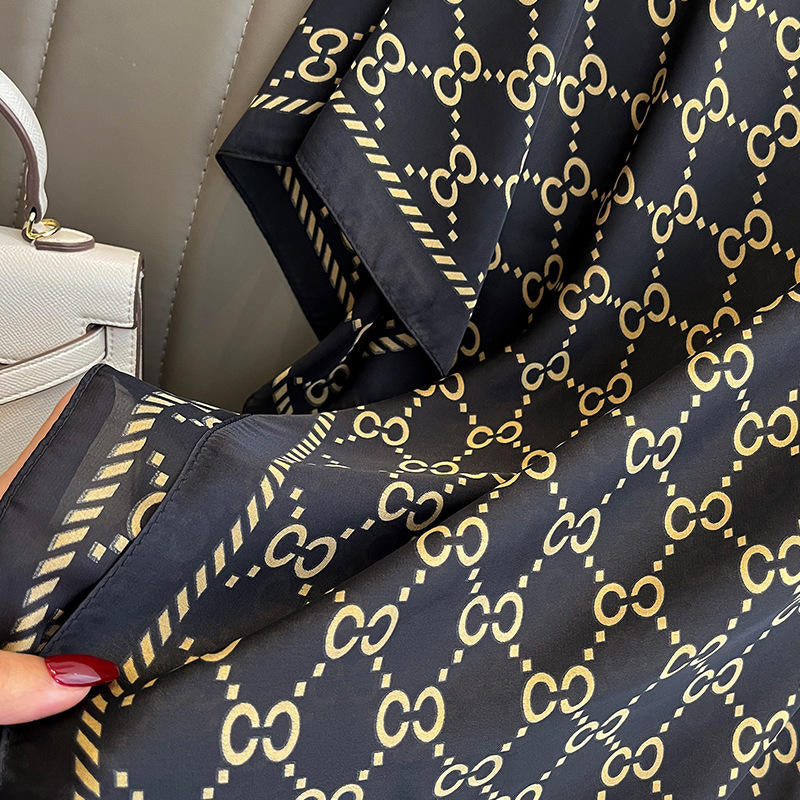 Discover timeless style with this luxurious silk-feel satin scarf. Featuring a classic black and gold monogram and an iconic red and green striped border, this 90 x 180 cm scarf is the epitome of elegance.