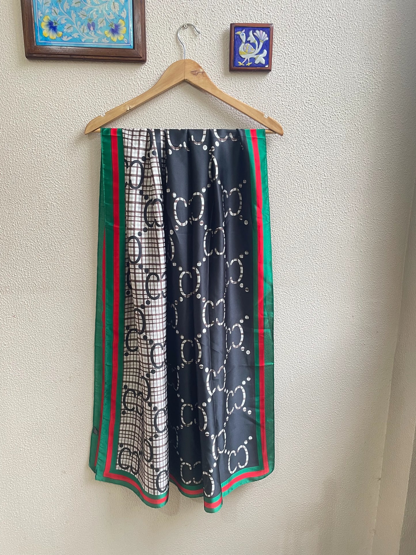 Discover this luxurious silk-feel satin scarf with a unique split design of black and plaid monogram, framed by an iconic red and green border. Measures 90 x 180 cm. The perfect statement accessory.