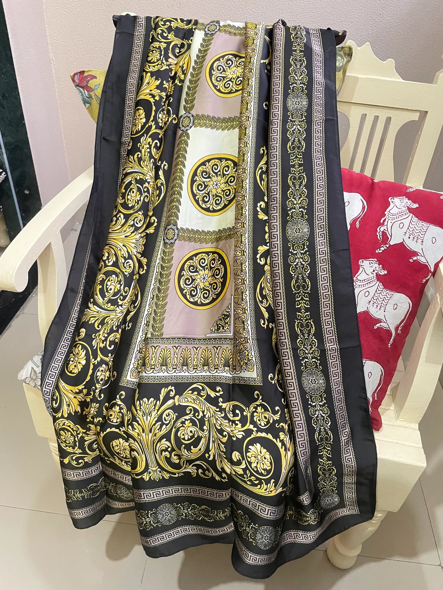 Indulge in luxury with this stunning silk-feel satin scarf. Features an ornate gold and black baroque scrollwork pattern with a Greek key border. Measures 90 x 180 cm. Perfect for adding a touch of regal elegance.