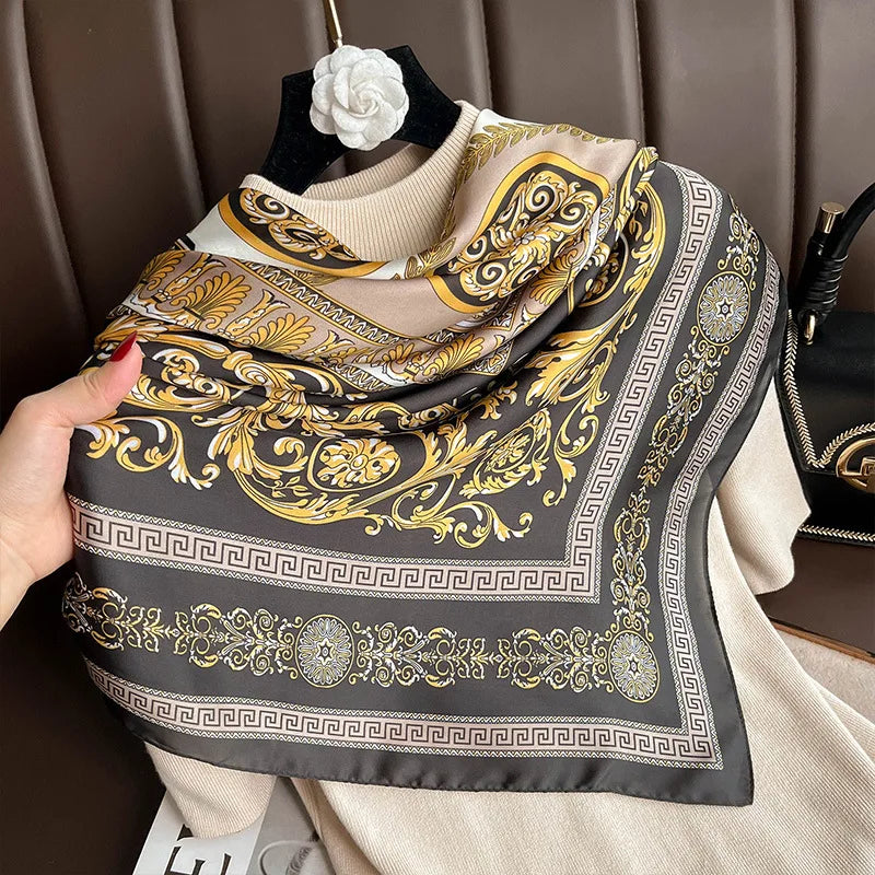 Indulge in luxury with this stunning silk-feel satin scarf. Features an ornate gold and black baroque scrollwork pattern with a Greek key border. Measures 90 x 180 cm. Perfect for adding a touch of regal elegance.