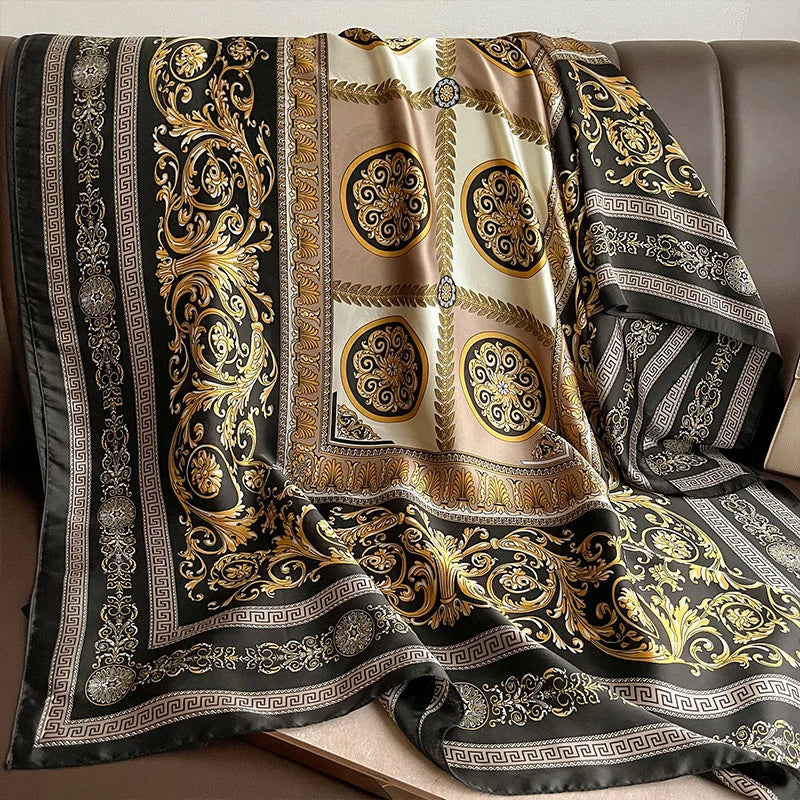Indulge in luxury with this stunning silk-feel satin scarf. Features an ornate gold and black baroque scrollwork pattern with a Greek key border. Measures 90 x 180 cm. Perfect for adding a touch of regal elegance.