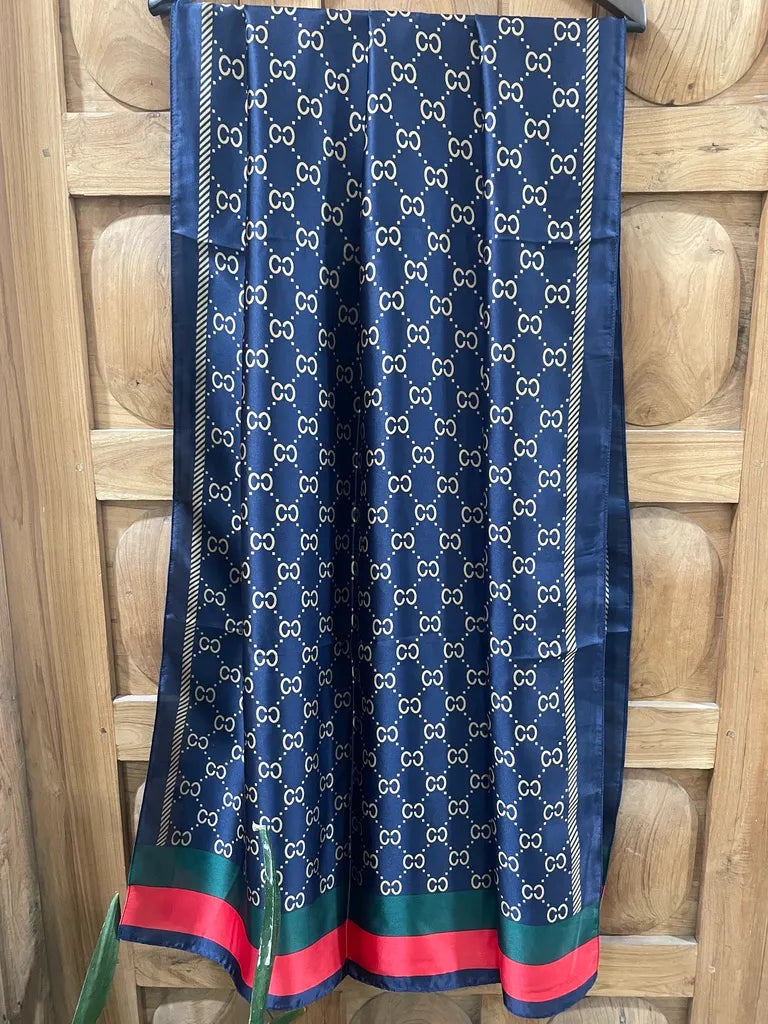 Elevate your style with this luxurious silk-feel satin scarf. Features a deep navy and gold monogram design with iconic red and green stripes. Size 90 x 180 cm.