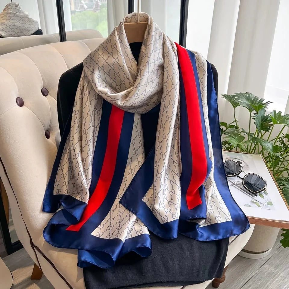 Elevate your style with this luxurious silk-feel satin scarf in white monogram with bold red and blue stripes. Measuring 90 x 180 cm, it’s perfect for evening wear, travel, or as a sophisticated gift.