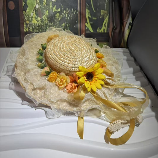 Embrace countryside charm with our Marisol sunflower straw hat. This vintage-inspired boater features a ruffled lace brim, pearl accents, and flowing yellow ribbons. Perfect for summer events.