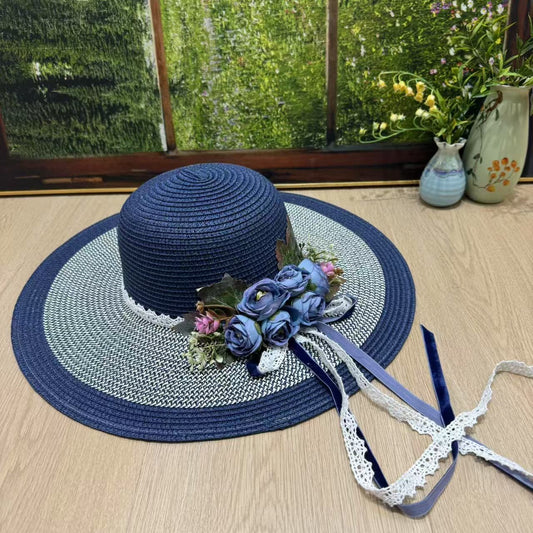 Navy blue wide-brim sun hat with blue roses, pink florals, greenery, and lace velvet ribbons