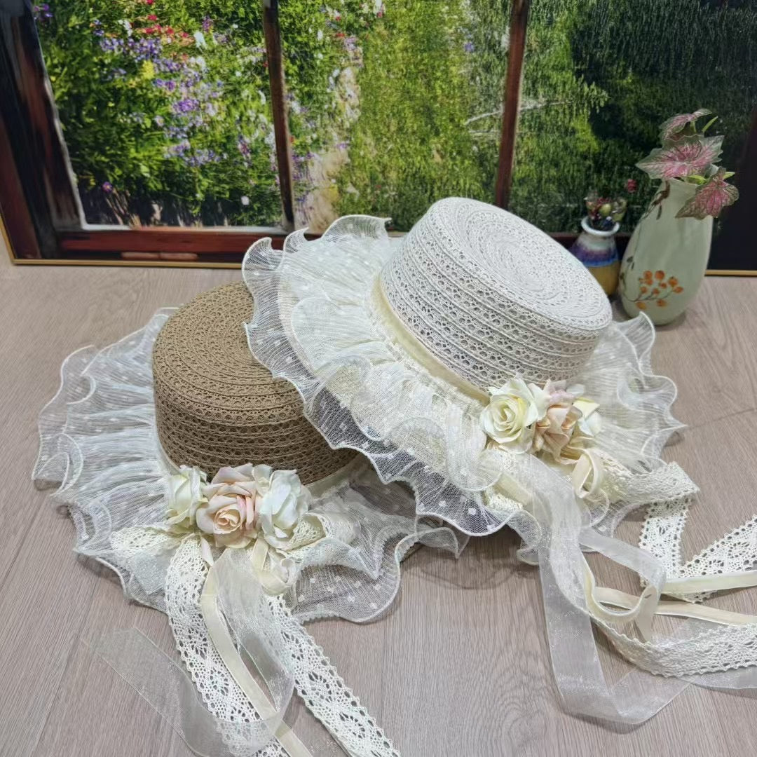An Victorian-style bonnet hat with a woven papyrus crown and a ruffled cotton lace brim, decorated with cream and pink roses and long trailing lace ribbons.