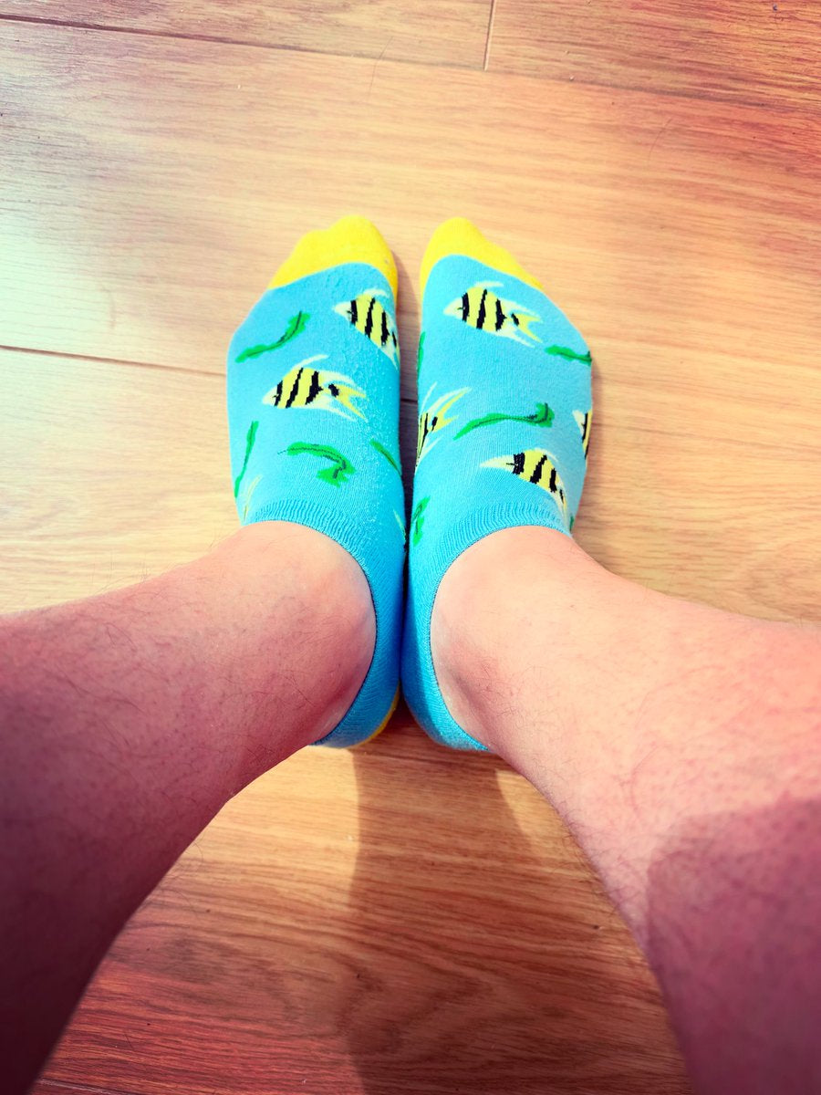 quirky blue socks with a fish pattern worn on a wooden floor