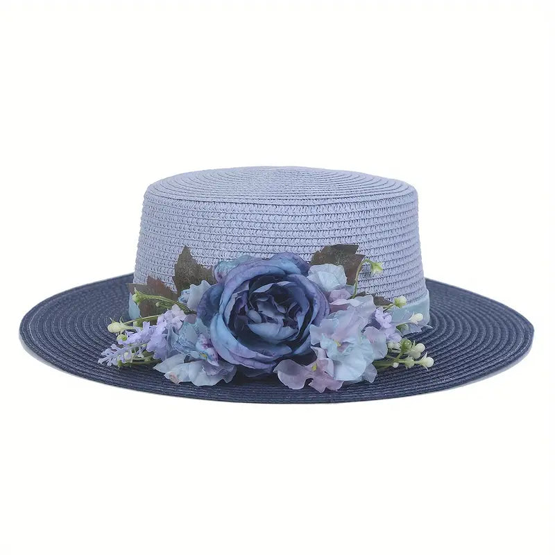 Vintage blue floral boater hat made of papyrus with layered blue flowers and ribbon, displayed on wicker basket with garden-themed decor.