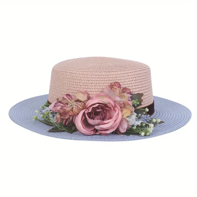 Vintage pink and blue floral boater hat made of papyrus with mauve roses and greenery, displayed on wicker basket with rustic decor.