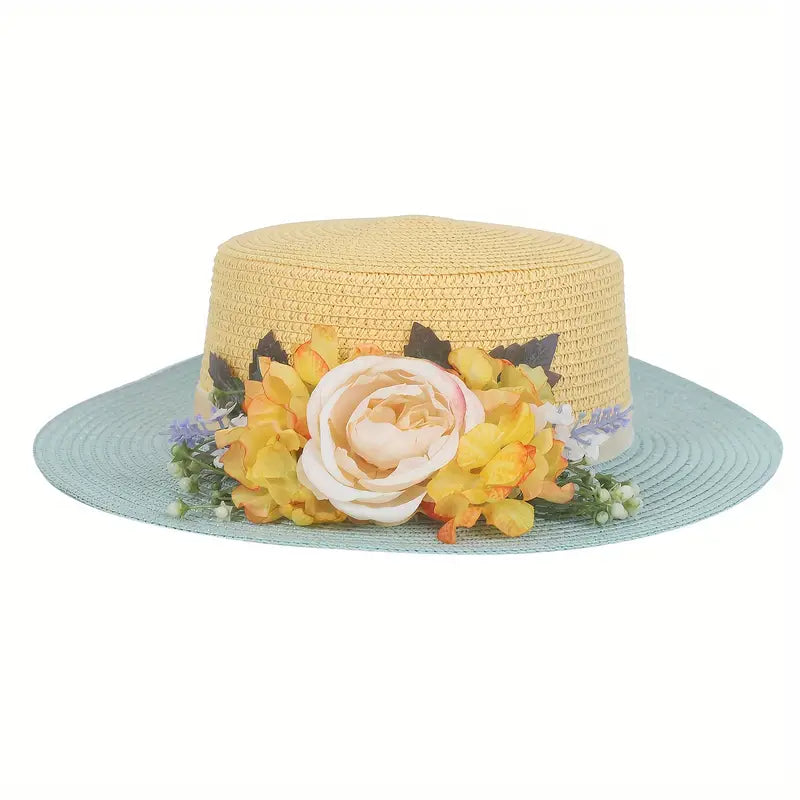 Vintage yellow and blue floral boater hat made of papyrus with yellow blossoms and cream rose, displayed on wicker basket with rustic decor.