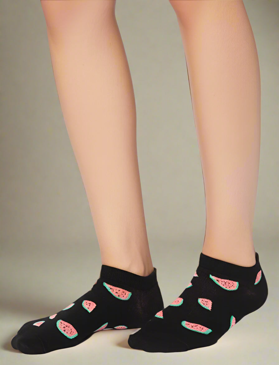 Black socks with watermelon pattern worn by a person on a white background