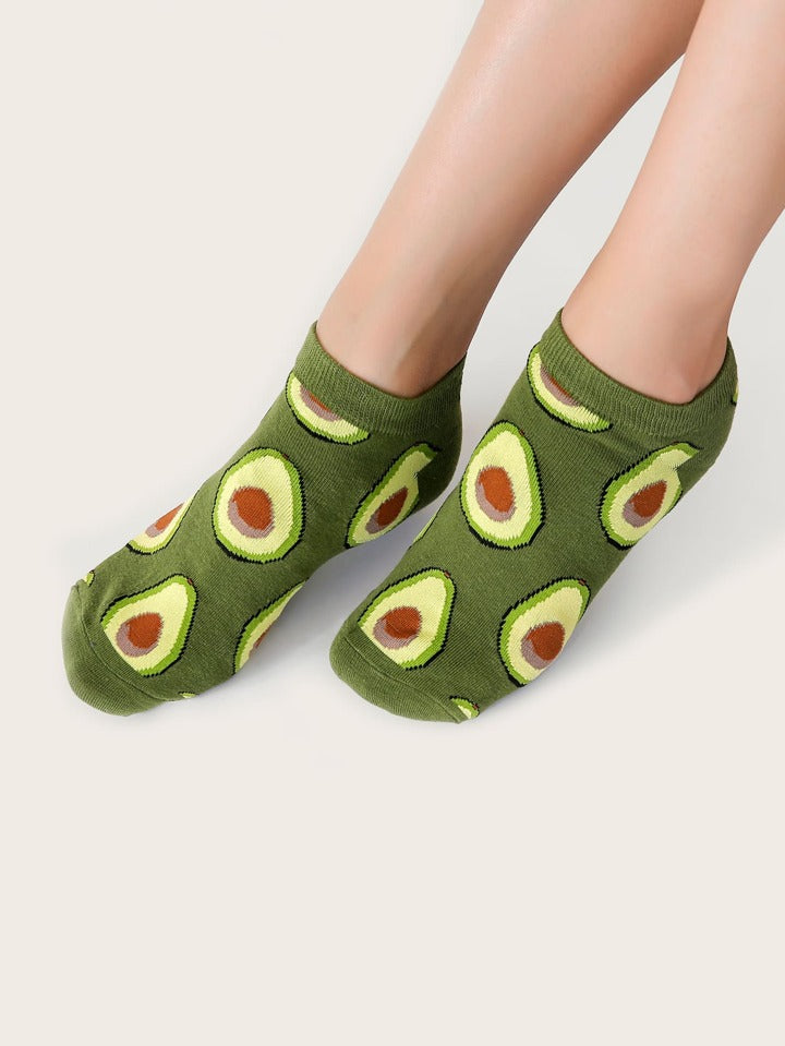 Green socks with avocado pattern worn by a person on a light gray background
