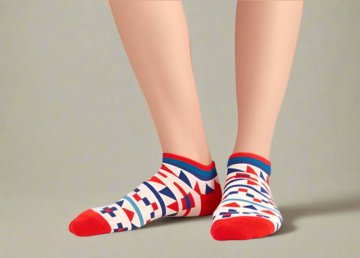 Colorful patterned socks with red toes and heels on a plain background