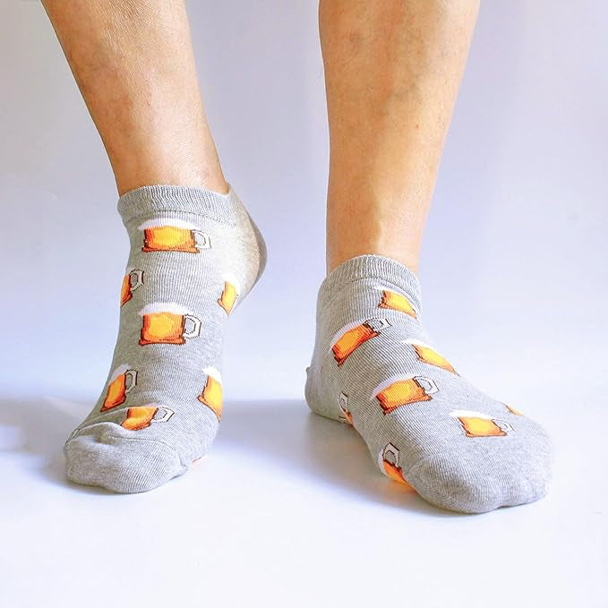 Gray socks with beer mug patterns worn by a person on a white background