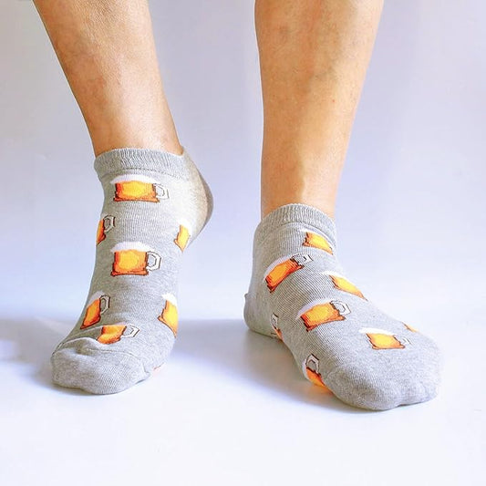 Gray socks with beer mug patterns worn by a person on a white background