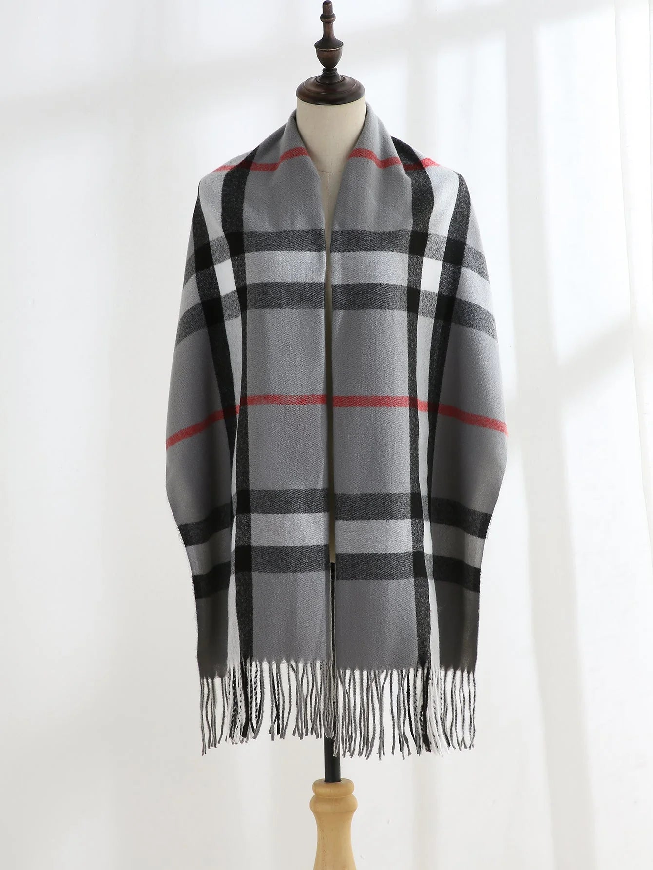 Plaid scarf with gray, black, and red colors on a mannequin against a white background