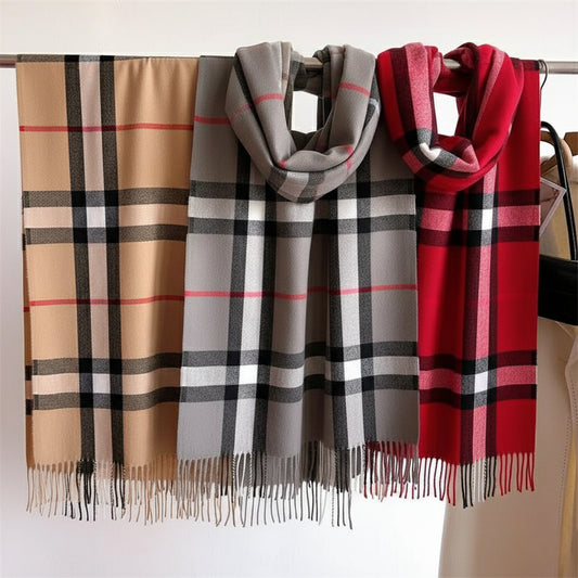 Three plaid scarves in beige, gray, and red hanging on a rack.