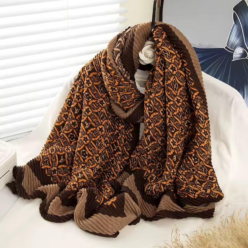 Elegant brown and beige monogram pleated scarf draped over a chair