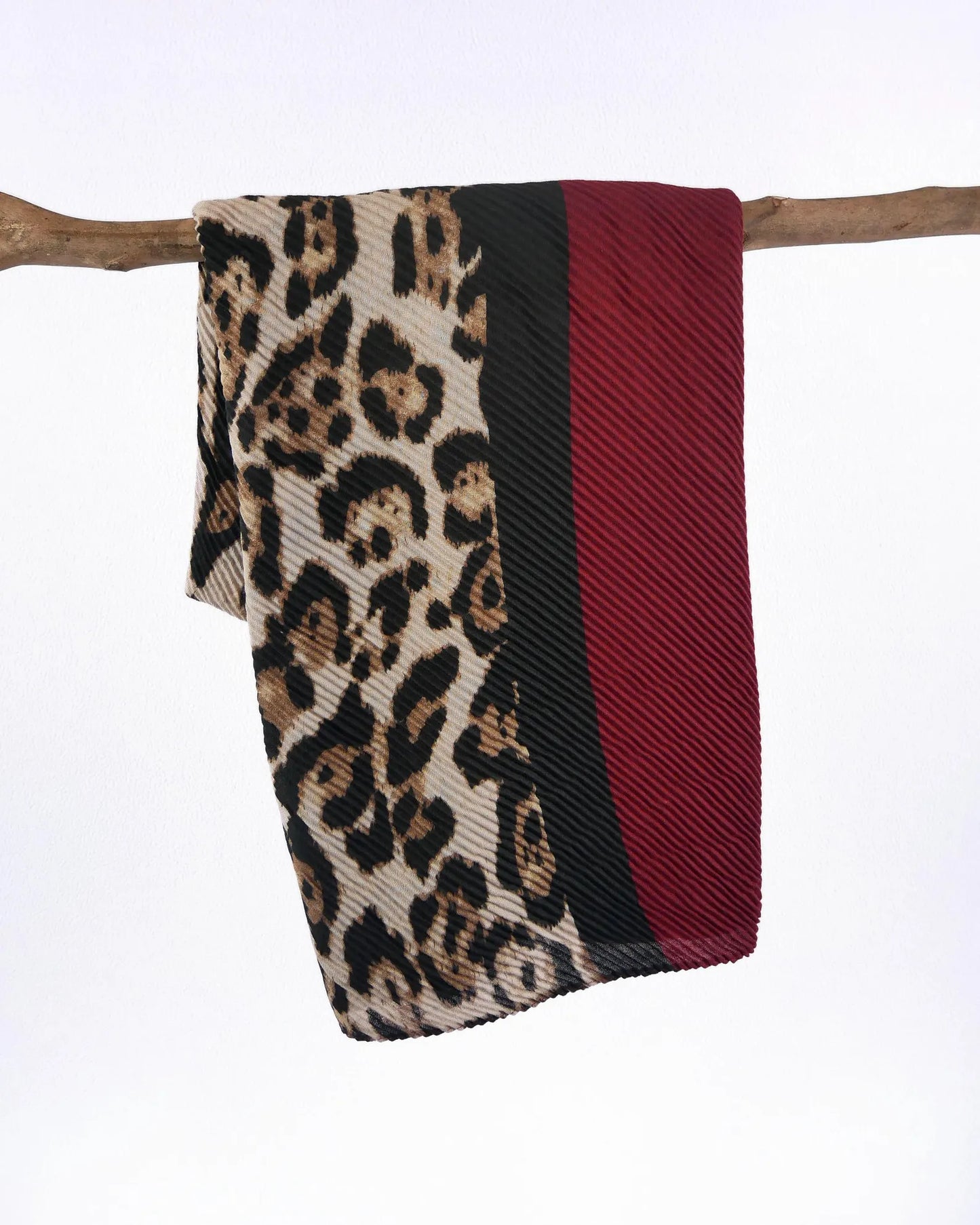 Scarf with leopard print, black stripe, and red pattern on a white background