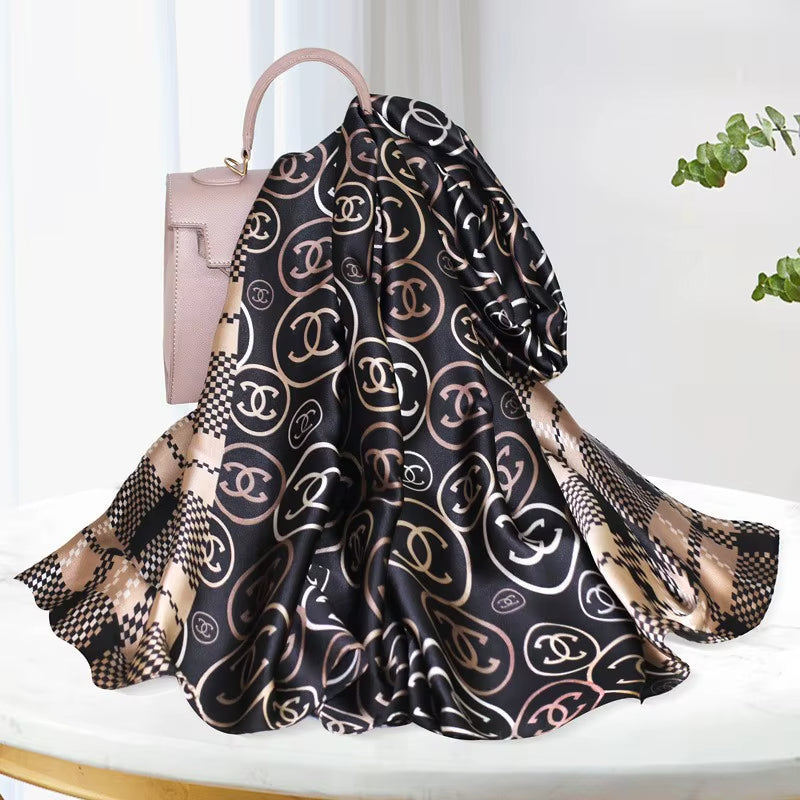 Discover ultimate versatility with this luxurious silk-feel satin scarf. Featuring a unique dual pattern of a chic beige & black check and a classic monogram, this 90 x 180 cm scarf offers multiple styling options.