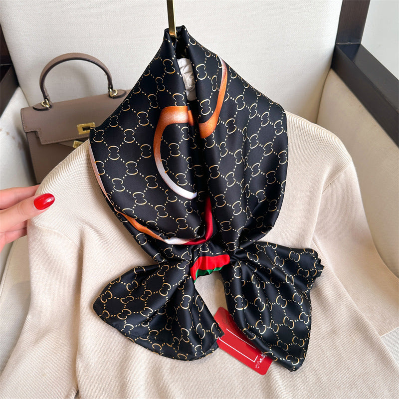 Discover sophistication with this luxurious silk-feel satin scarf. Featuring a black and gold monogram, a bold abstract graphic, and a signature red and green stripe, this 90 x 180 cm scarf is a true statement piece.