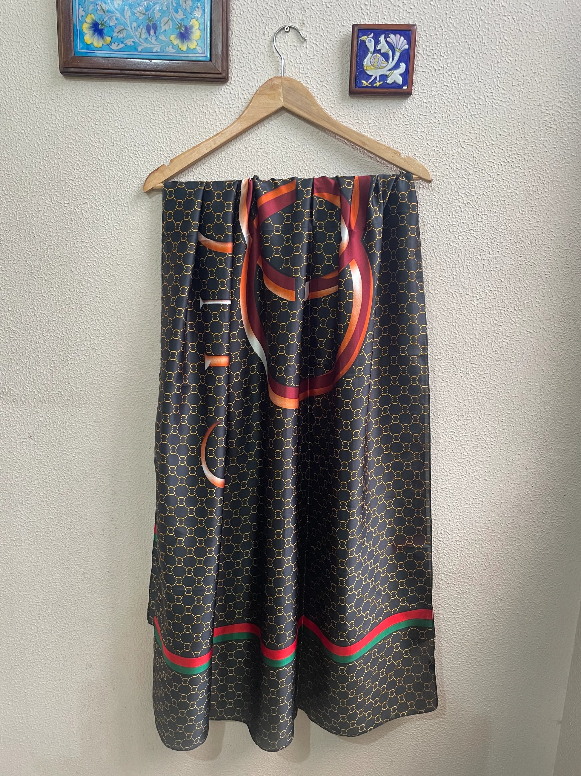 Discover sophistication with this luxurious silk-feel satin scarf. Featuring a black and gold monogram, a bold abstract graphic, and a signature red and green stripe, this 90 x 180 cm scarf is a true statement piece.