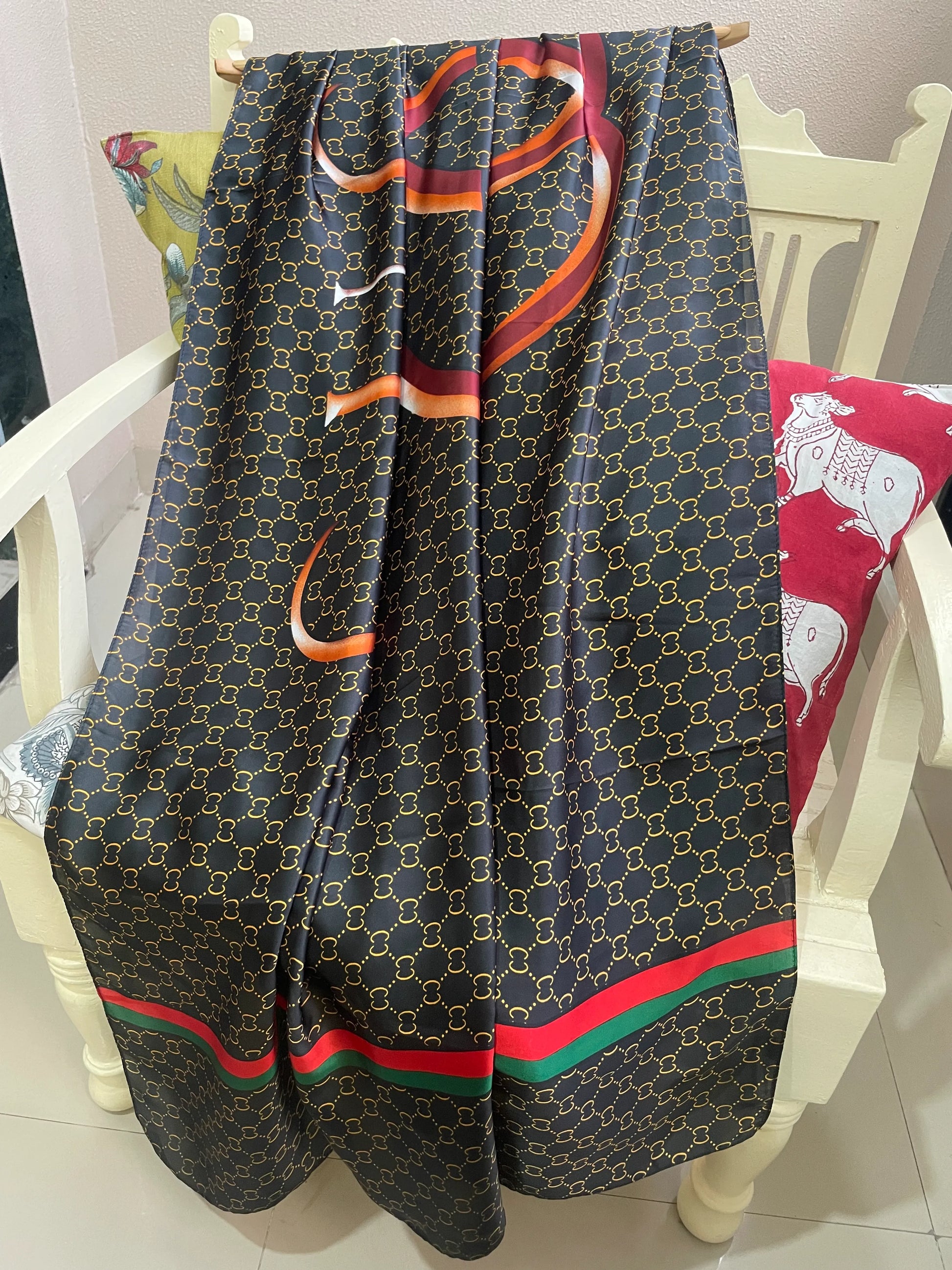 Discover sophistication with this luxurious silk-feel satin scarf. Featuring a black and gold monogram, a bold abstract graphic, and a signature red and green stripe, this 90 x 180 cm scarf is a true statement piece.