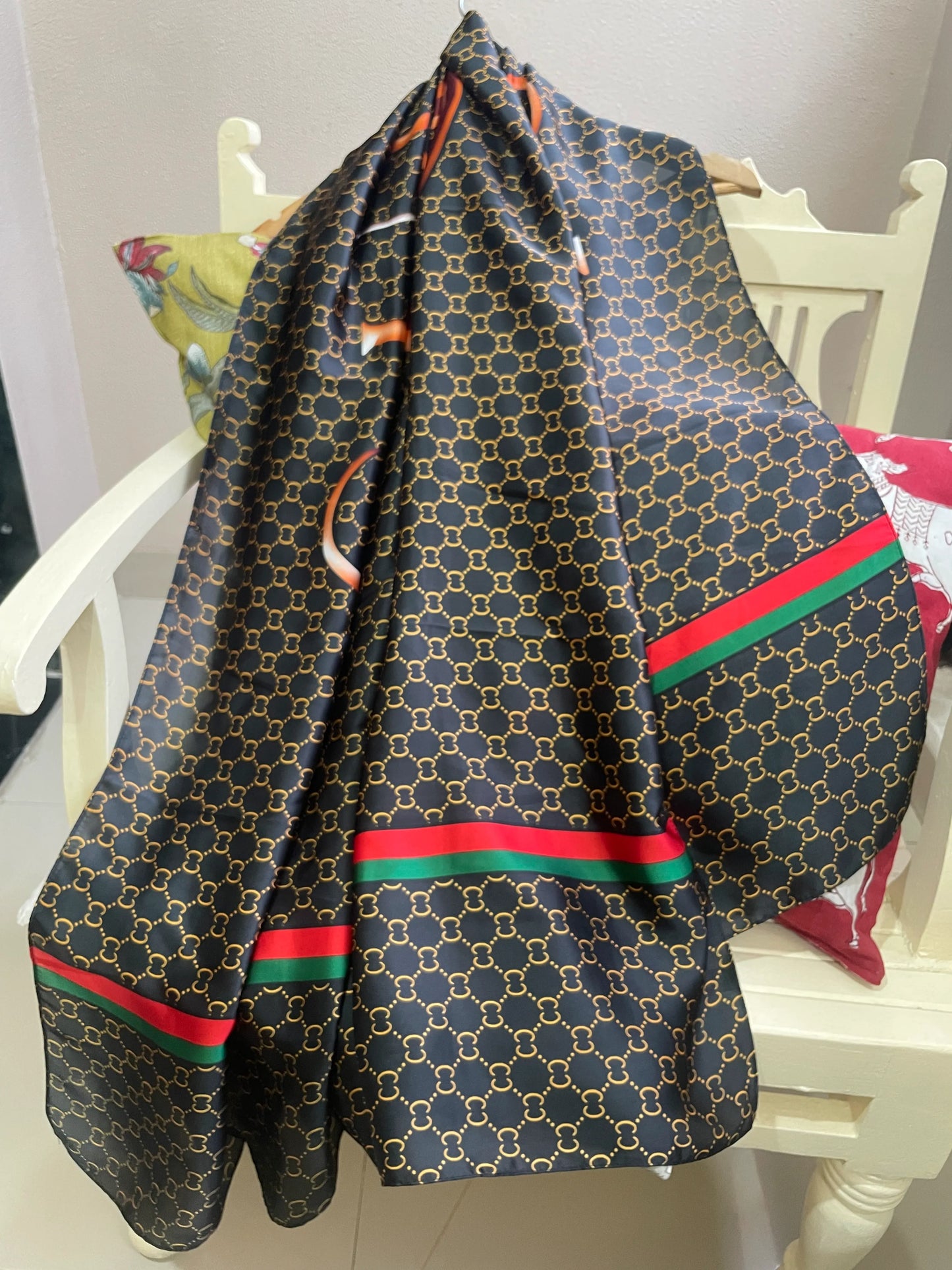 Discover sophistication with this luxurious silk-feel satin scarf. Featuring a black and gold monogram, a bold abstract graphic, and a signature red and green stripe, this 90 x 180 cm scarf is a true statement piece.