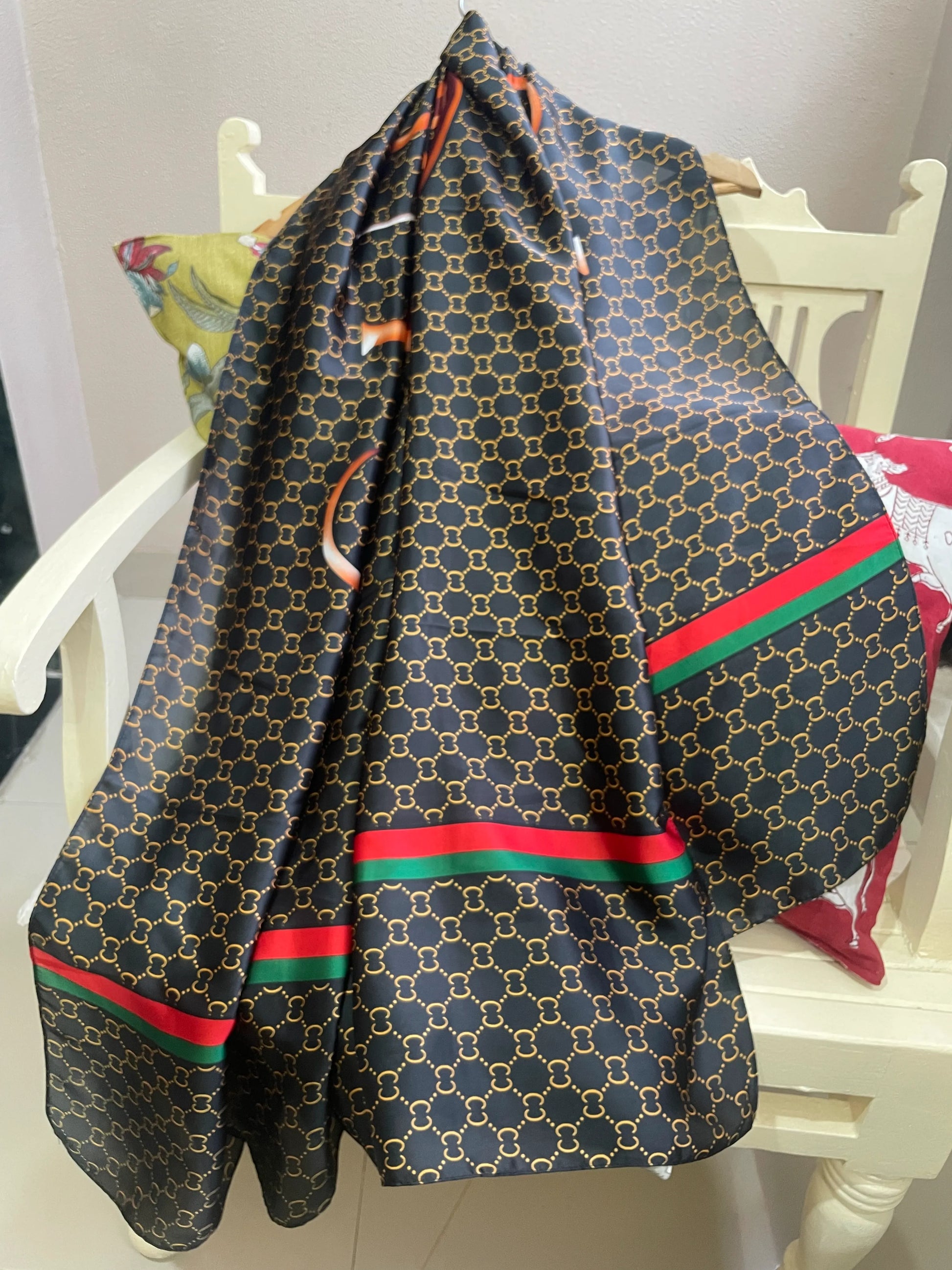 Discover sophistication with this luxurious silk-feel satin scarf. Featuring a black and gold monogram, a bold abstract graphic, and a signature red and green stripe, this 90 x 180 cm scarf is a true statement piece.