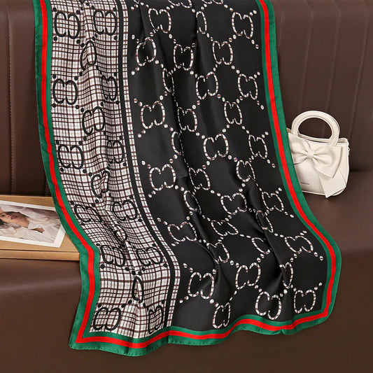 Discover this luxurious silk-feel satin scarf with a unique split design of black and plaid monogram, framed by an iconic red and green border. Measures 90 x 180 cm. The perfect statement accessory.