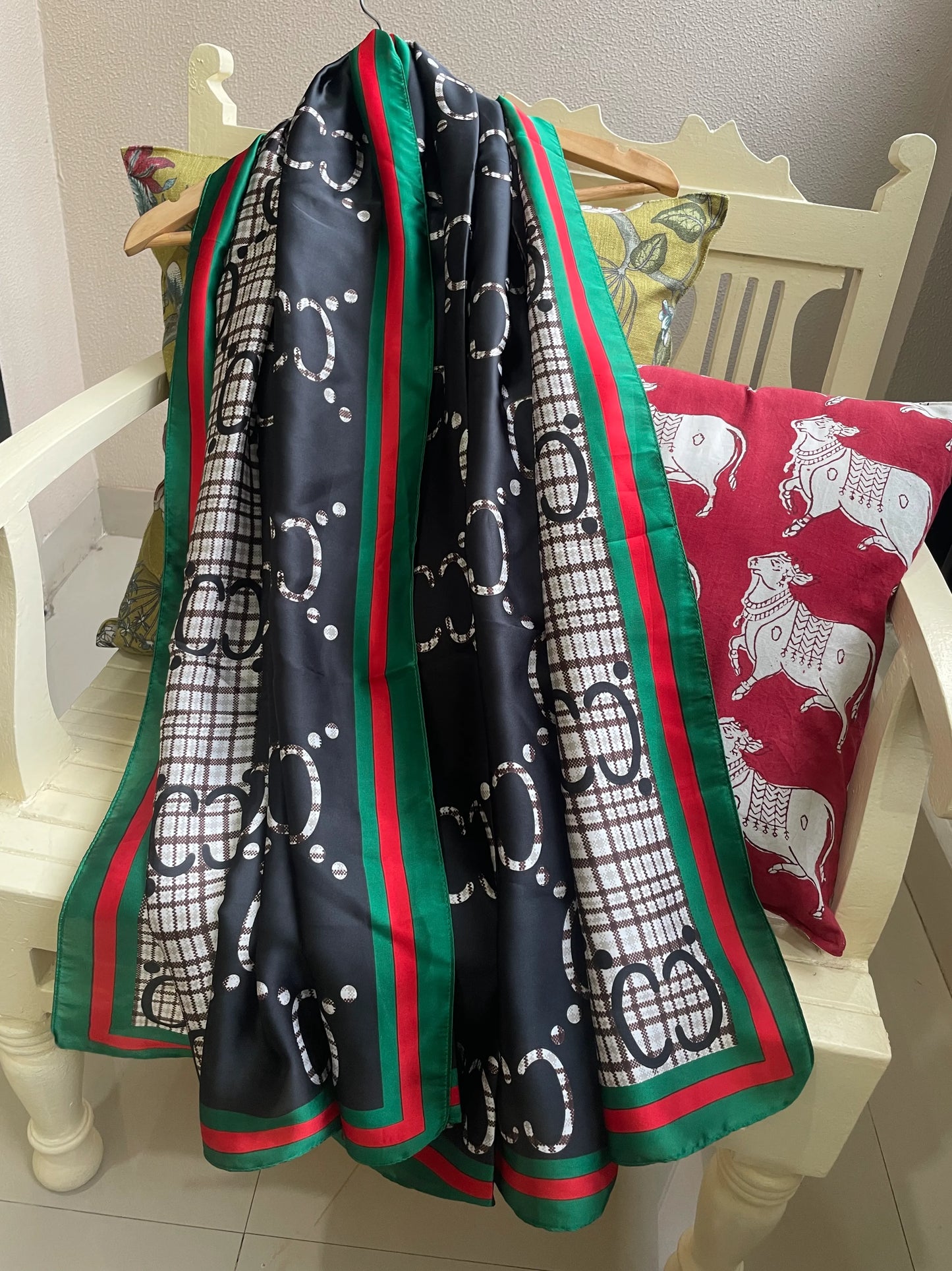 Discover this luxurious silk-feel satin scarf with a unique split design of black and plaid monogram, framed by an iconic red and green border. Measures 90 x 180 cm. The perfect statement accessory.