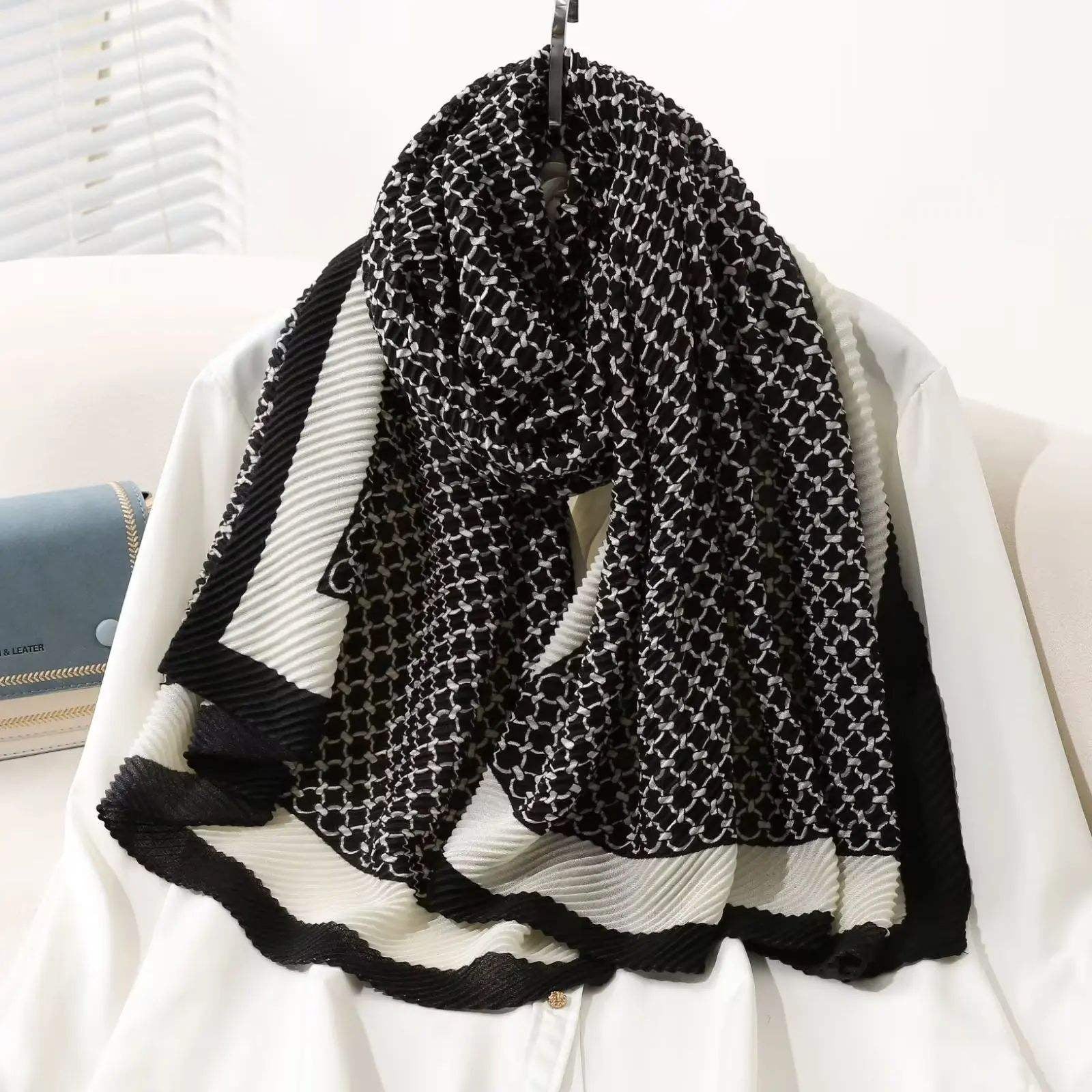 Luxury black and white geometric pattern pleated scarf draped on a mannequin
