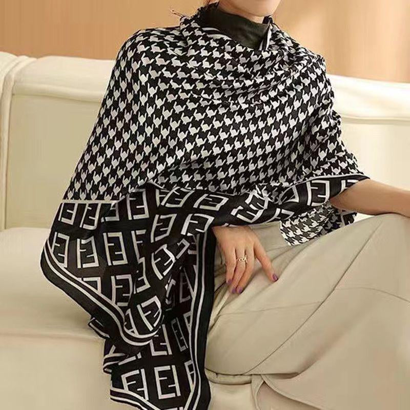 Elevate your wardrobe with this luxurious silk-feel satin scarf. Featuring a timeless black and white houndstooth pattern complemented by a modern monogram border, this 90 x 180 cm scarf is the definition of chic.