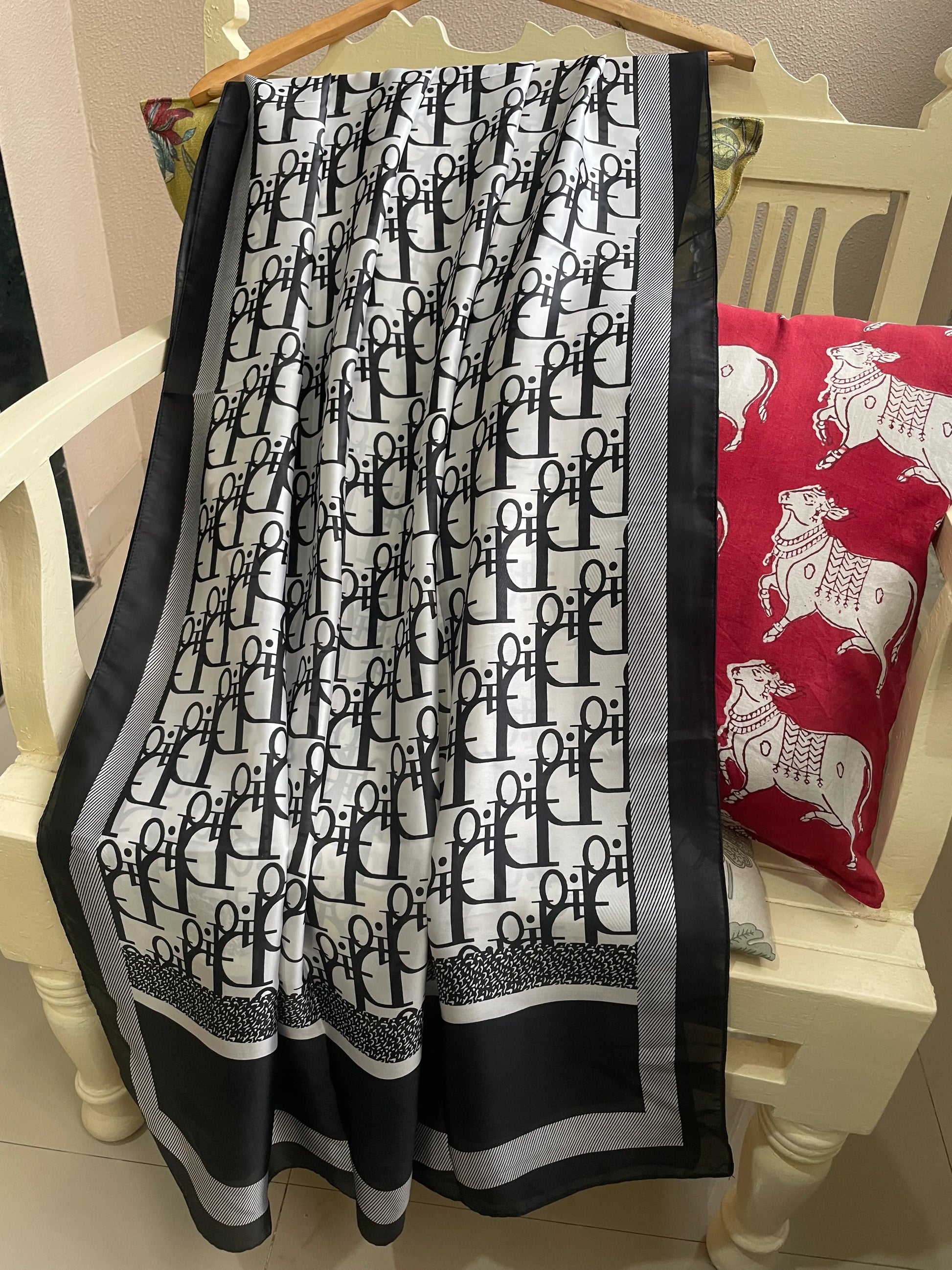 Elevate your style with this luxurious silk-feel satin scarf. Featuring a bold black and white monogram print with elegant contrasting borders, this 90 x 180 cm scarf is the epitome of chic sophistication.