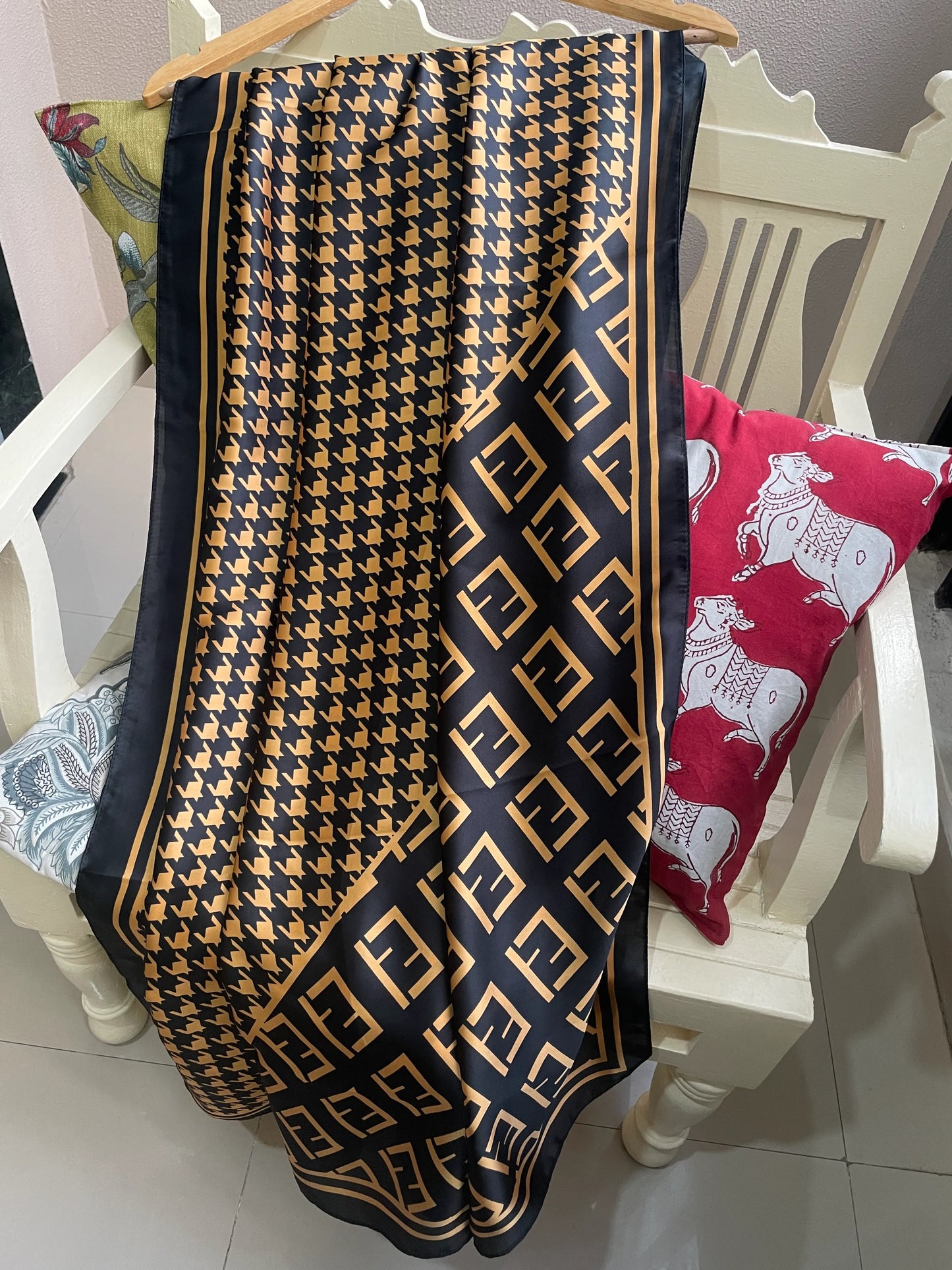 Elevate your wardrobe with this luxurious silk-feel satin scarf. Featuring a timeless gold and black houndstooth pattern complemented by a modern monogram border, this 90 x 180 cm scarf is the definition of chic.
