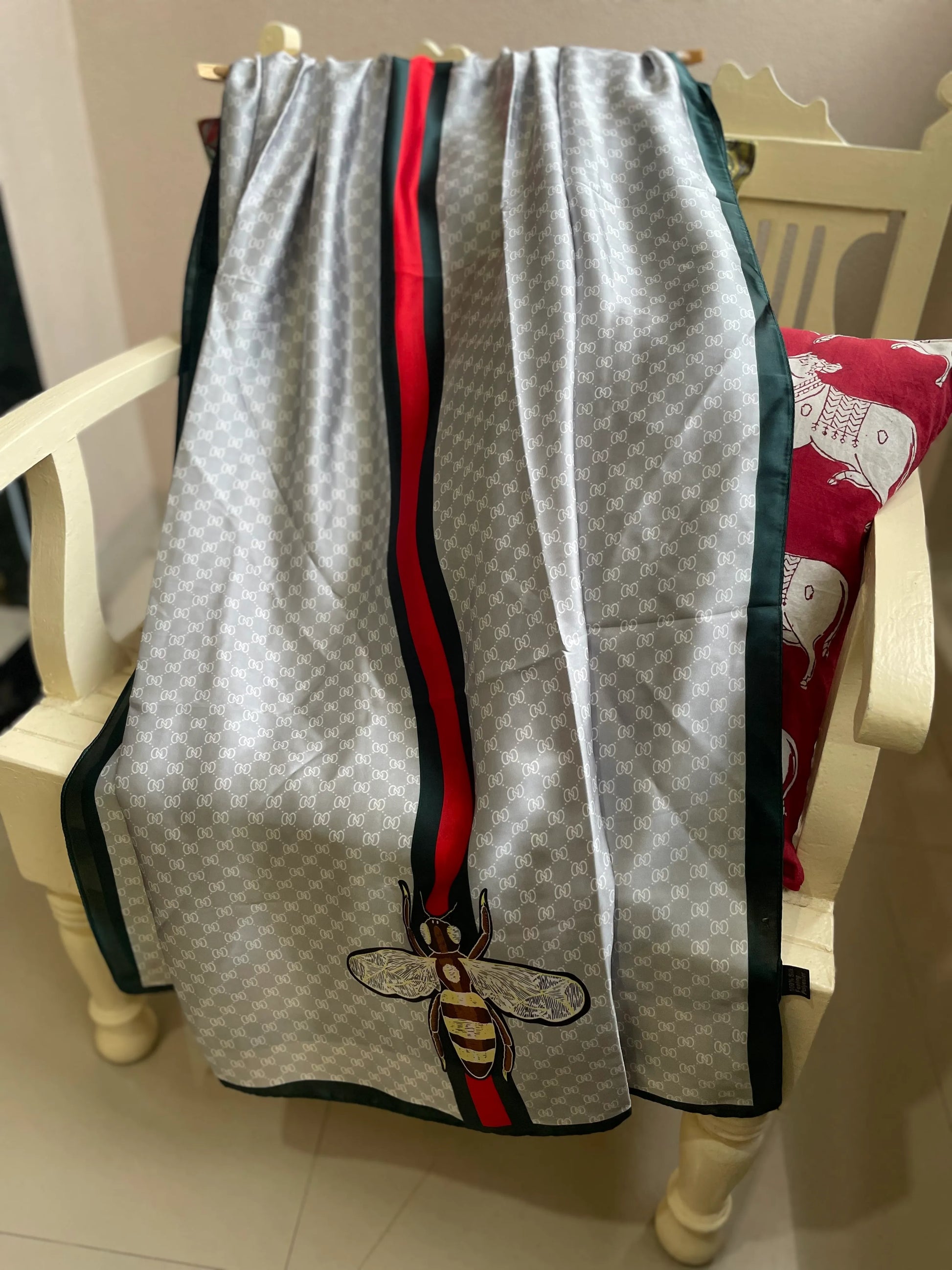 Elevate your style with this luxurious silk-feel satin scarf in light grey monogram with a bold red and green stripe and charming bee motif. Measuring 90 x 180 cm, it’s perfect for evening wear, travel, or as a sophisticated gift.

