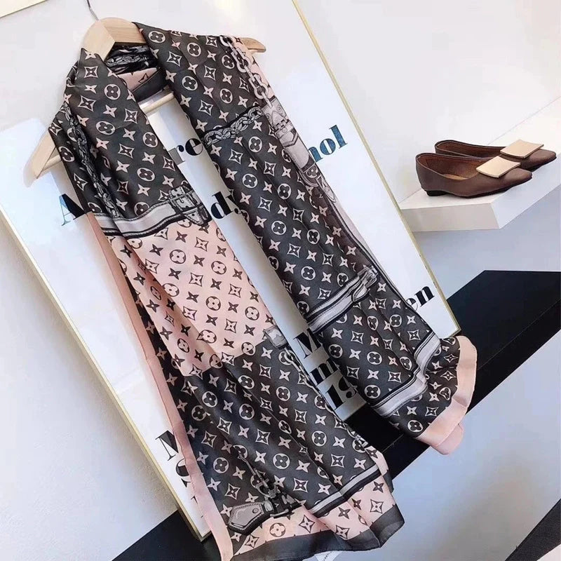 Elevate your style with this luxurious silk-feel satin scarf in delicate pink, elegant grey, and white with an iconic monogram pattern. Measuring 90 x 180 cm, it’s perfect for evening wear, travel, or as a sophisticated gift.
