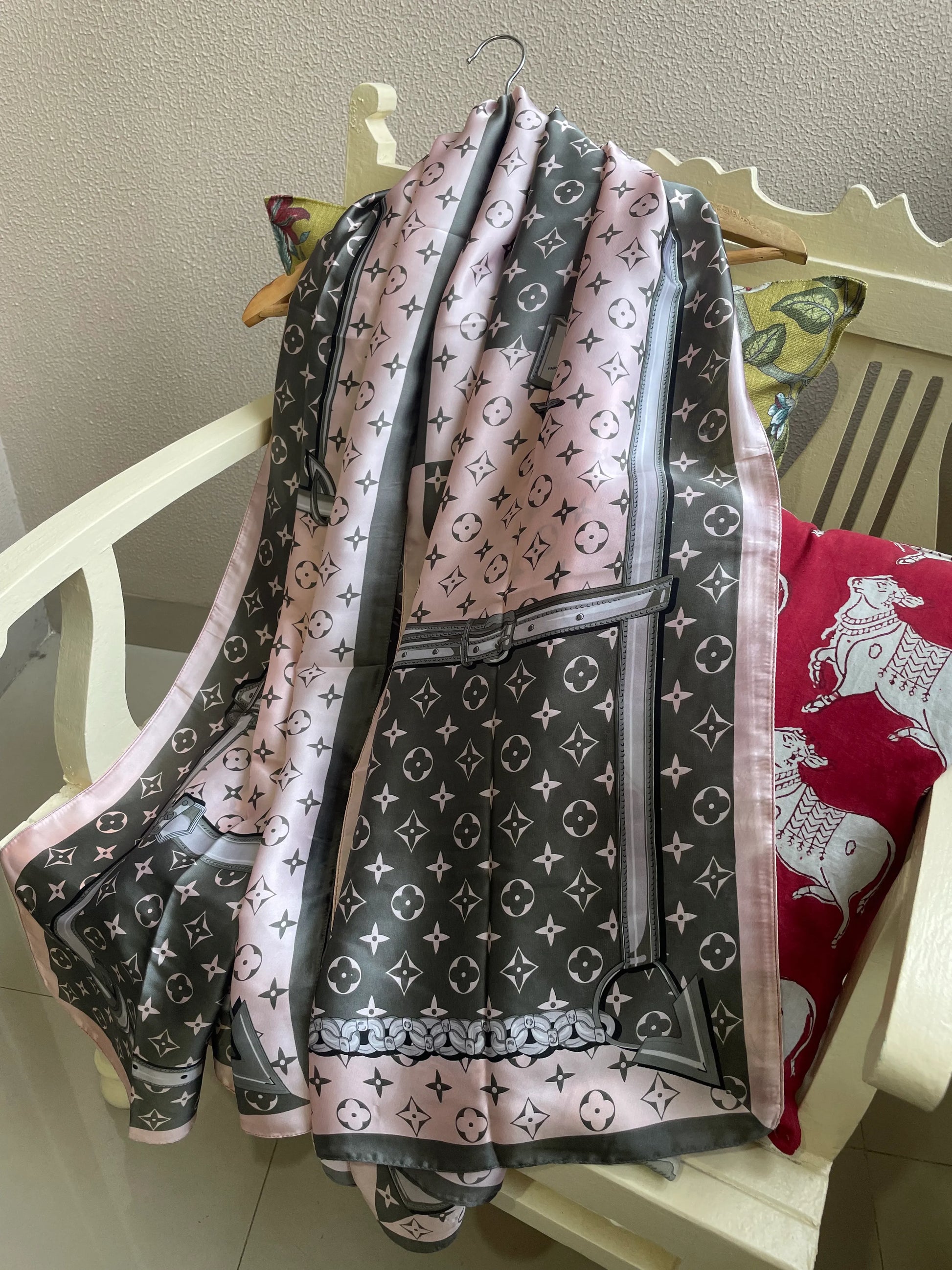 Elegant pink, grey, and white designer satin scarf draped over a chair – monogram print