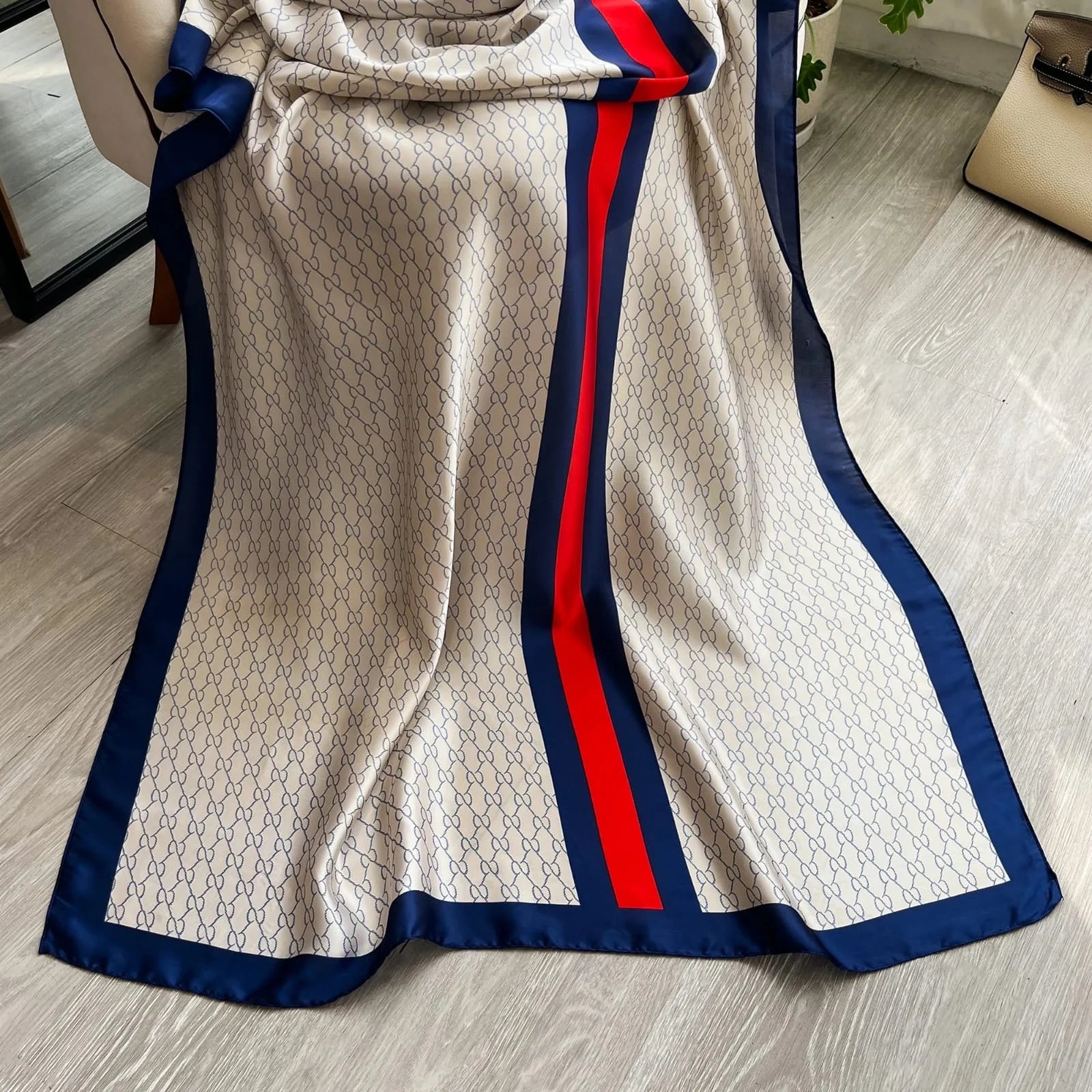 Elevate your style with this luxurious silk-feel satin scarf in white monogram with bold red and blue stripes. Measuring 90 x 180 cm, it’s perfect for evening wear, travel, or as a sophisticated gift.
