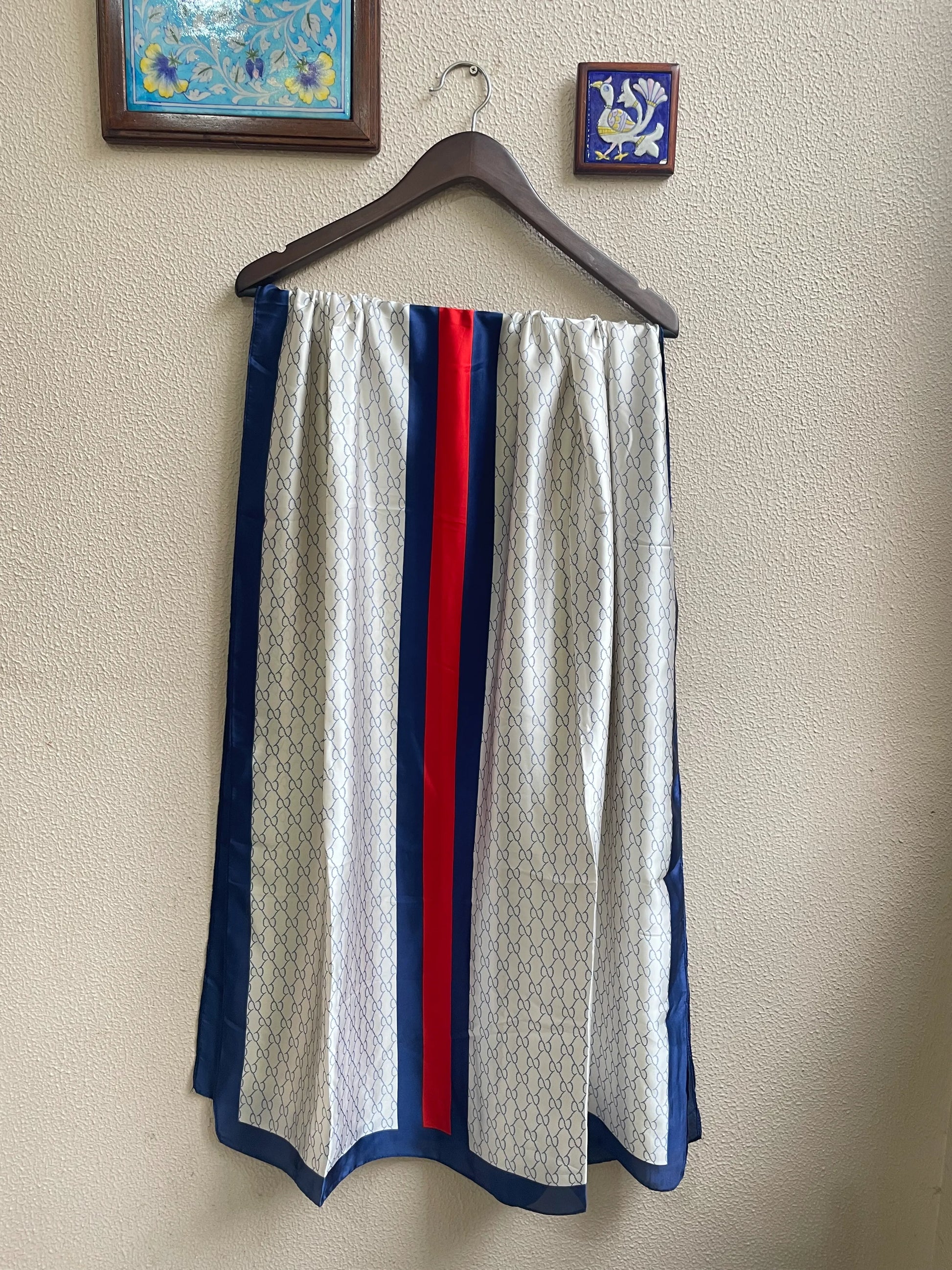 Elevate your style with this luxurious silk-feel satin scarf in white monogram with bold red and blue stripes. Measuring 90 x 180 cm, it’s perfect for evening wear, travel, or as a sophisticated gift.
